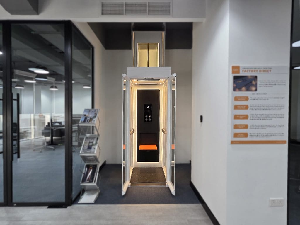 Cibes Ascenda mini home lift on display in the Dubai showroom, doors open with warm cabin lighting.