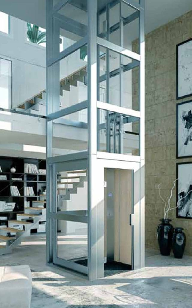 Traction home elevator with framed glass shaft in a modern villa.