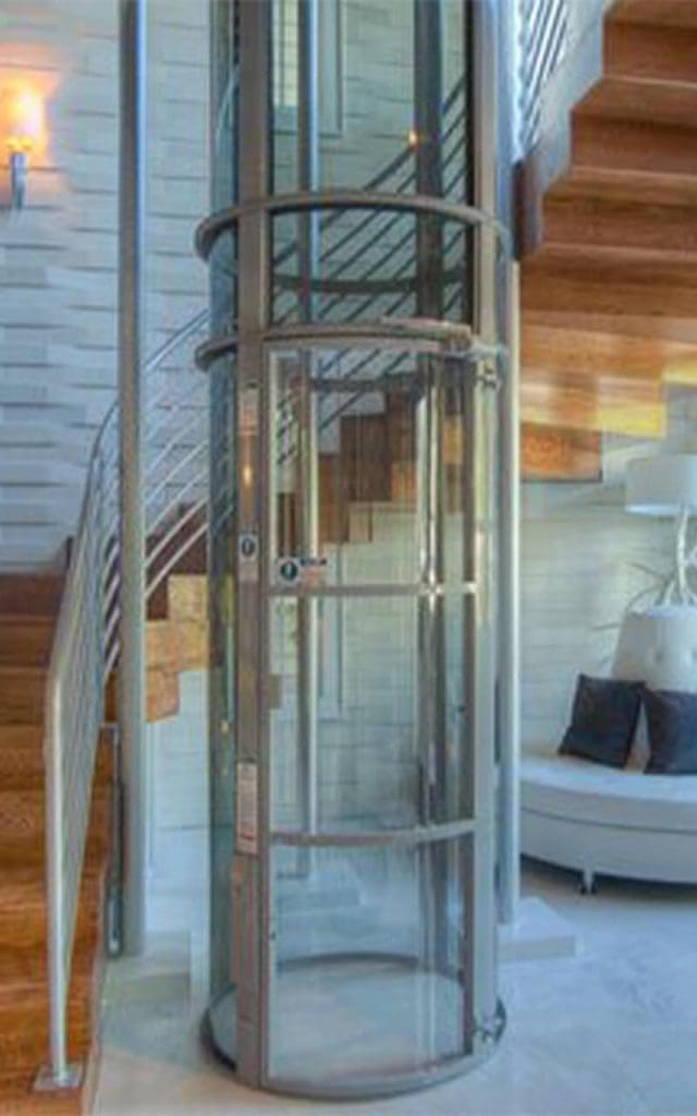 Vacuum home lift installed beside a staircase in a modern villa.