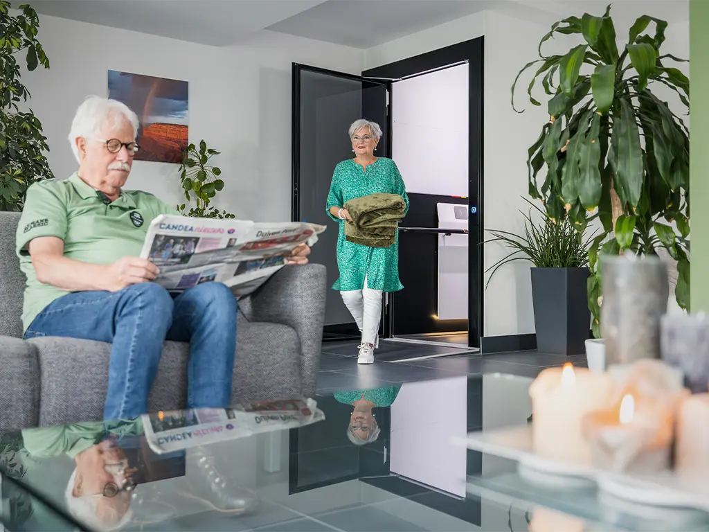 Elderly couple using a home lift inside a modern house for daily mobility.