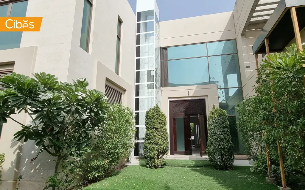 Cibes outdoor home lift installed on a modern villa exterior in Dubai with a glass shaft beside the entrance.