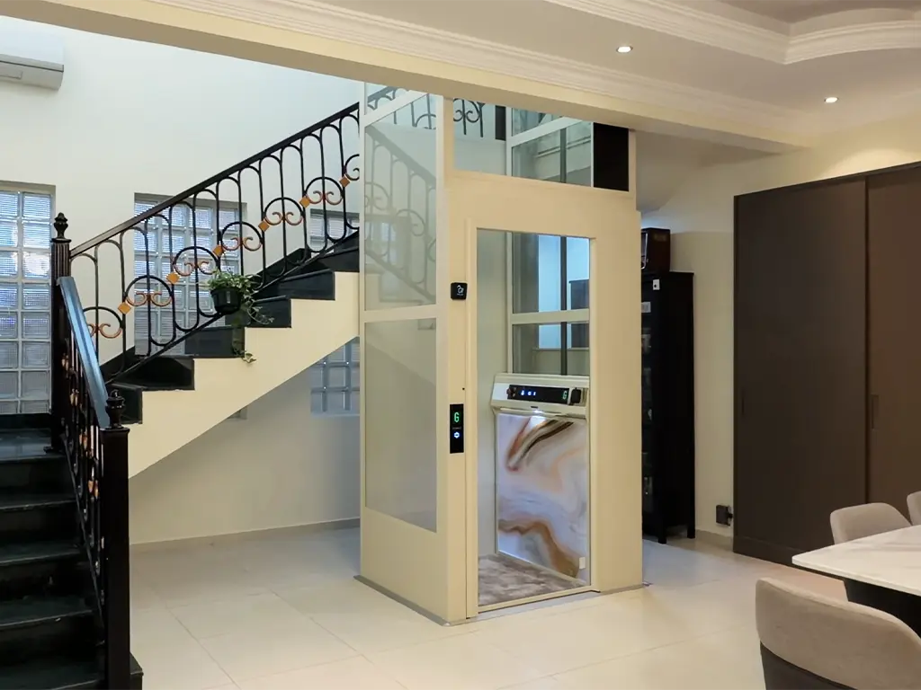 Cibes home lift installed beside a staircase inside a modern villa.