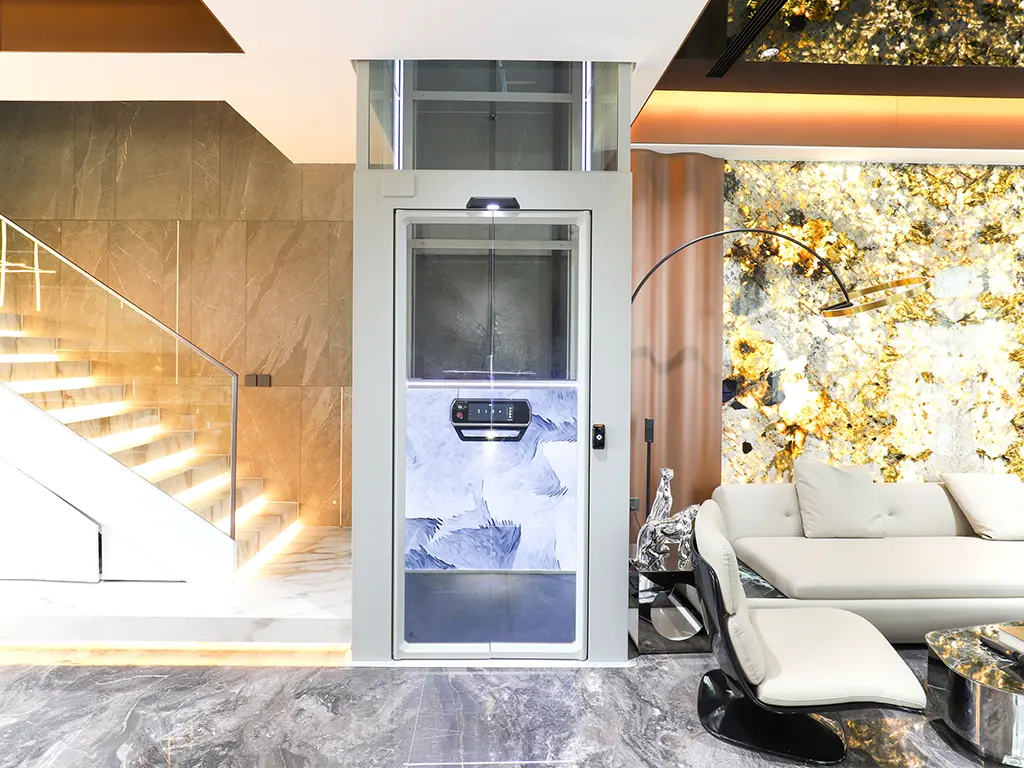 Cibes V80 home lift installed in a luxury villa interior beside an illuminated staircase.