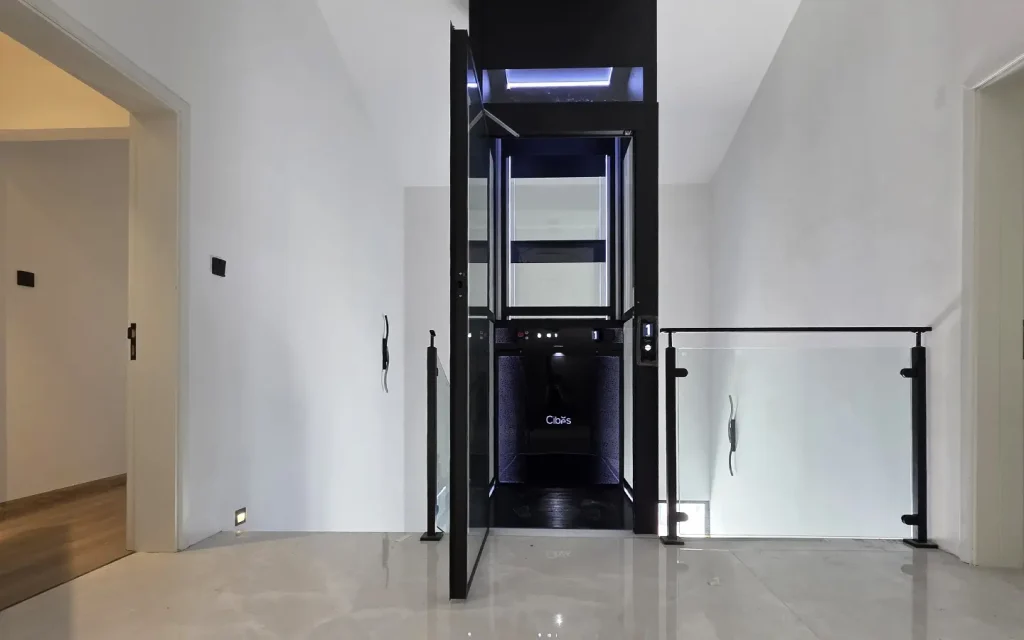 Cibes Voyager home lift installed in the middle of a staircase inside a modern villa.
