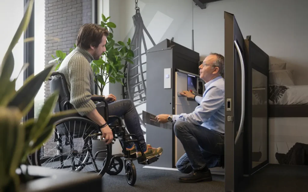 Wheelchair user discussing home lift accessibility options with a lift specialist.