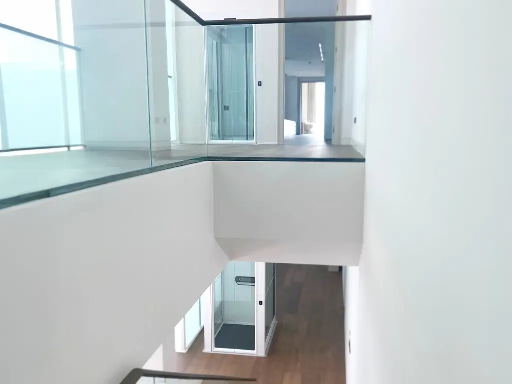 Cibes V90 2-stop home lift installed inside a bright modern penthouse with a white panoramic shaft.