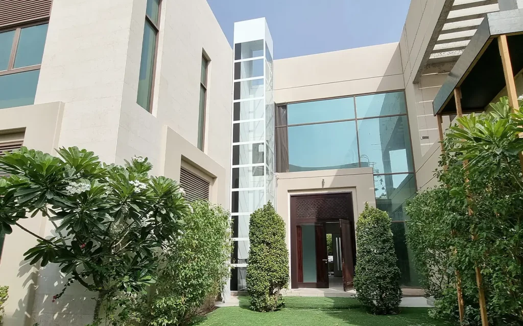 Cibes outdoor home lift installed beside a modern villa in the UAE with a panoramic glass shaft.